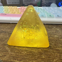 Jouet souple translucide en forme de pyramide avec paillettes, texture de surface à grains fins, motif en relief sur le devant, à presser pour se détendre