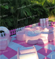 Ensemble d'équipements de jeux gonflables pastel rose avec château gonflable, piscine à balles fleurie et manège pour enfants, idéal pour la location de fêtes d'anniversaire
