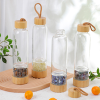 Bouteille d'eau en verre infusée de cristaux naturels avec couvercle en bambou et pierres précieuses à l'intérieur