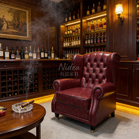 Fauteuil Chesterfield de luxe vintage en cuir rouge bordeaux, design capitonné, structure ergonomique et durable, roulettes en laiton, pour club et bar