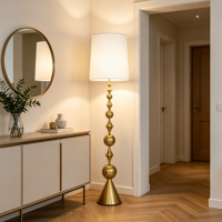 Lampadaire sculptural doré à abat-jour cylindrique blanc, base conique à tiges empilées, lampe sur pied moderne pour salon et hôtel