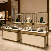 Vitrine de présentation de bijoux et montres pour toute la boutique, en verre arrondi couleur or champagne, finition crème mate, OEM pour bijouterie phare