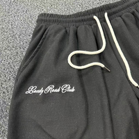 Shorts en tricot gaufré pour hommes, taille élastique, cordon de serrage contrastant blanc, poches latérales, coupe ample, longueur genou, style streetwear