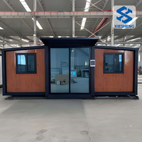 Maison conteneur pliable et extensible en acier préfabriqué, 2 chambres, 1 salle de bain, entièrement meublée, installation rapide et économique, pour usage résidentiel ou bureau.