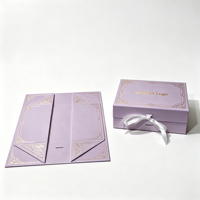 Boîte rigide pliable mat lilas avec motif européen gaufré, logo estampé à chaud, fermeture à ruban, boîte cadeau