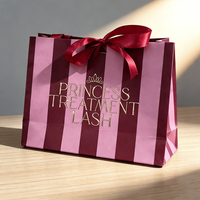 Sac cadeau en papier rayé rose et bordeaux personnalisé avec poignée en ruban de satin et logo imprimé en feuille d'or pour emballage de beauté haut de gamme