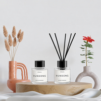Diffuseur de parfum compact en bouteille transparente avec bâtonnets en fibre noire absorbante pour une diffusion de parfum stable dans les chambres