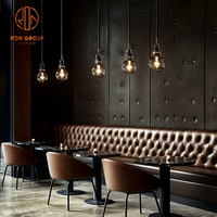 Ensemble de mobilier de restaurant Ron Group : banquette capitonnée personnalisée, table ronde en marbre et chaises en cuir