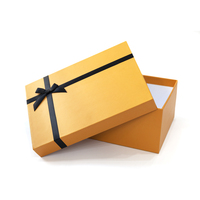 Boîte cadeau en papier orange de luxe avec ruban personnalisable et couvercle sécurisé pour l'emballage de produits haut de gamme