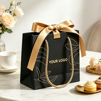 Sac fourre-tout en papier noir de luxe personnalisé avec logo OEM, motif floral doré, poignée en corde satinée pour emballage cadeau de bijoux