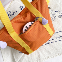 Sac bandoulière décontracté en nylon color block pour femme, grande capacité, avec pendentif et bandoulière large détachable, idéal pour les trajets quotidiens