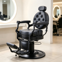 Chaise de coiffure noire gothique, cuir capitonné rond, accoudoirs en métal mat et base circulaire sur pied.
