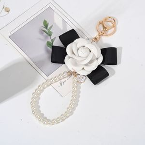 Llavero de Moda con Flor de Camelia, Lazo de Cinta Negra <span class=keywords><strong>y</strong></span> Correa de Perlas Artificiales, Elegante Colgante para Bolso de Uso Diario - Product Image 4