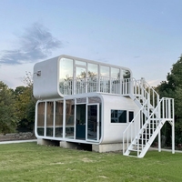 Maison préfabriquée modulaire de luxe à deux étages, type « Apple Cabin », avec terrasse et escalier, pour usage en hôtel, villa ou maison d'hôtes en station balnéaire