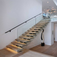 Escalier minimaliste mono-échelle en métal noir avec balustrade en verre pour la maison