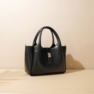 Una borsa in pelle semplice e di nicchia tenuta in mano da donna con un Design grande ed elegante è una borsa A tracolla a spalla singola e sotto le ascelle - Product Image 2