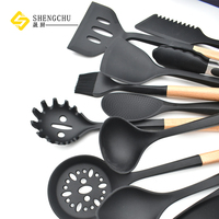 Nouveau design accessoires de cuisine 13 pièces ensemble d'ustensiles de cuisine en Silicone avec support en plastique en forme de cœur et poignée en bois