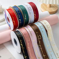 Kişiselleştirilmiş logo ve 3D kabartmalı altın varak detaylarıyla süslenmiş özel lüks polyester saten-grosgrain kurdele.