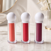 Gloss à lèvres en tubes facettés, capuchon sphérique blanc nacré, pâte scintillante, applicateur doe foot floqué, teintes corail et baies, approvisionnement en gros, logo personnalisé