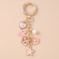 Nouveau porte-clés élégant en forme de coquillage, de queue de poisson et d'étoile de mer avec des perles et un charme en forme de cœur
