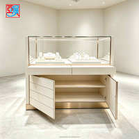 Comptoir de présentation de bijoux blanc crème avec tiroirs et armoire de rangement, vitrine à bijoux en verre avec finition dorée pour boutique de diamants