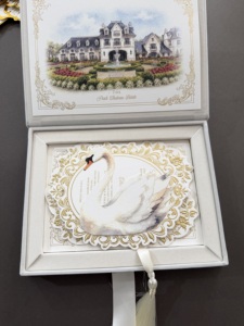 Caja de Invitación de Boda de Lujo en Forma de Libro, Reciclable, de Cartón Color Marfil, con Diseño de Cisne en Lámina Dorada, Forro de Satén, Cinta Decorativa, Caja Personalizada - Product Image 1