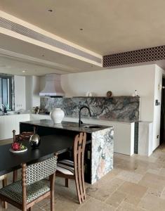 Cuisine moderne avec crédence en pierre naturelle et îlot, armoires blanches, étagères ouvertes - Product Image 2