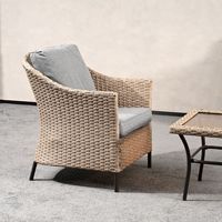 Ensemble de salon d'extérieur en rotin moderne haut de gamme avec canapé modulaire, table basse en verre et fauteuils assortis pour patio de villa