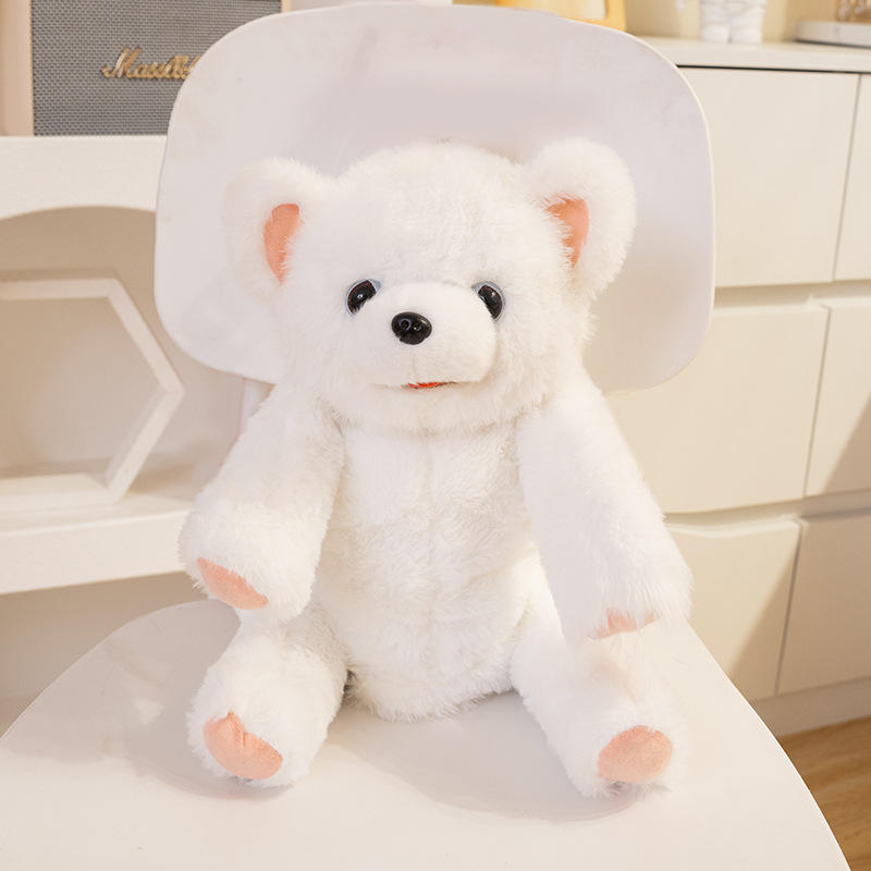 Petit ours blanc qui lèche le dos d'un sac à dos, chante pour apprendre à parler.