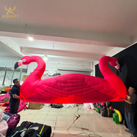Comptoir de bar gonflable flamant rose décoré pour festivals et mariages, avec plumes réalistes. Montage facile, oiseau gonflable pour exposition en bord de lac.
