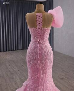 見事なピンクのスリット入りマーメイド・キンセアニェーラドレスは、片方の肩に大きなピンクの花が付いたプロムドレスで、フリル付きのチュールトレーンが特徴です。 - Product Image 4