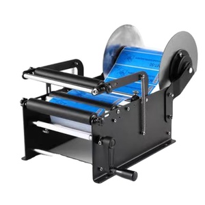 Machine d'étiquetage semi-automatique de bureau pour bouteilles rondes, pots et canettes de vin, boissons et spiritueux, avec application d'autocollants. - Product Image 1