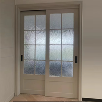Porte intérieure coulissante moderne en polymère français, avec grille en MDF sur mesure, isolation acoustique et vitrage simple pour cour.