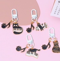 Porte-clés en alliage de zinc avec motif de petit chat noir musical de dessin animé et notes de piano, accessoire de sac mignon et original pour hommes et femmes