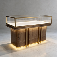 Comptoir d'exposition incurvé de luxe en verre avec base en marbre, cadre en métal noir et éclairage LED pour boutique de bijoux