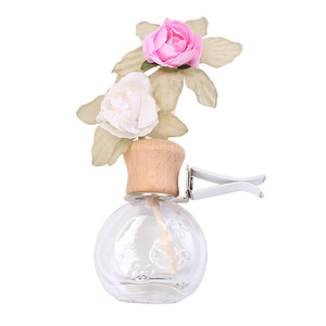 Diffuseur de voiture rond 15 ml avec clip de fixation pour grille d'aération et bâtonnets parfumés en forme de fleur - Product Image 1