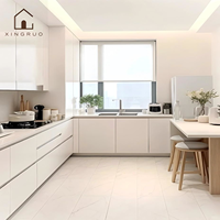 Lemari Dapur Modern Bentuk L XINGRUO dengan Pintu Slab Warna Krem, Unit Tinggi Motif Kayu, dan Meja Dapur Berpenampilan Batu