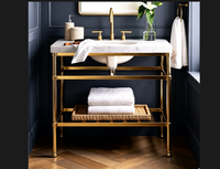 Meuble-lavabo haut de gamme pour suites de luxe, avec plateau en marbre de Carrare, pieds en acier inoxydable chromé poli et finition laiton doré brillant