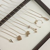 Collier pendentif vintage doré pour femme, avec breloques mignonnes en forme de cœur, nœud, croix, trèfle, collier ras-du-cou perlé, chaîne de pull, cadeau bijou