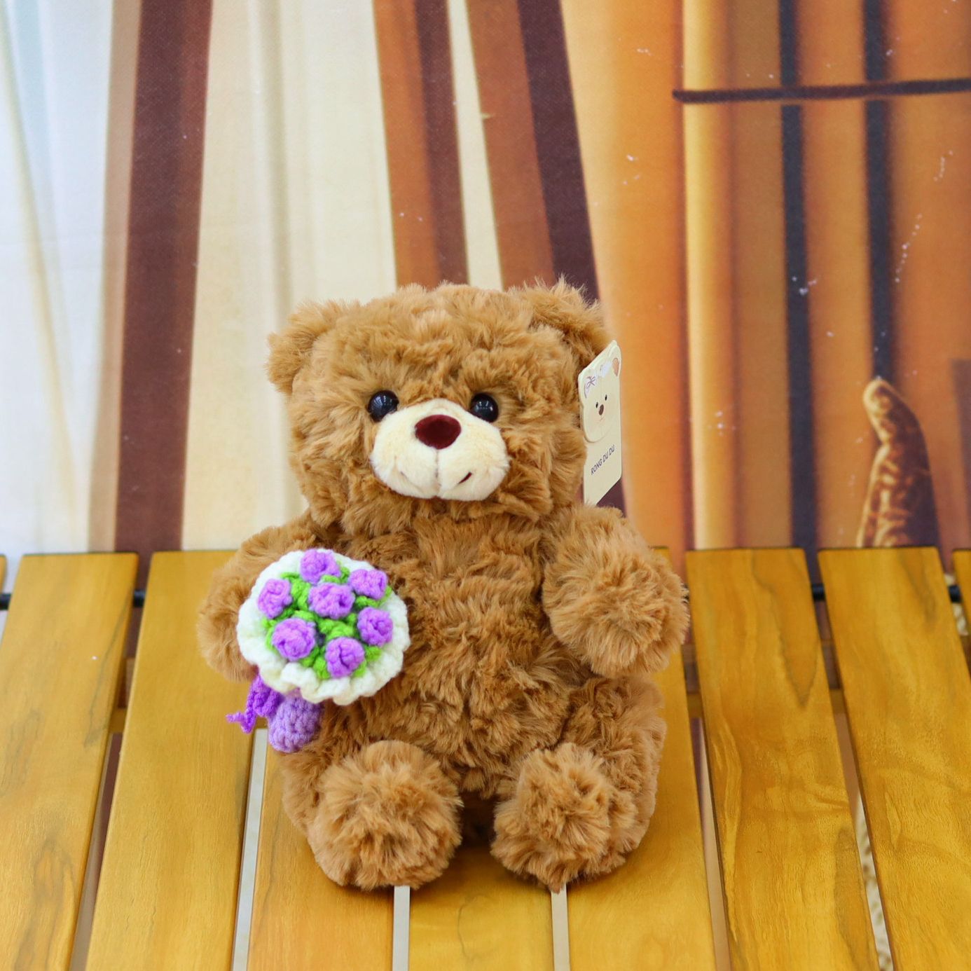 ours brun avec bouquet de fleurs violettes