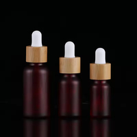 Botol Tetes Kaca Merah Buram dengan Logo Kustom Profesional dan Tutup Bambu untuk Penyimpanan Minyak Esensial Kosmetik Merek Kecantikan.