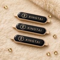 Plaque de logo en métal en alliage de zinc émaillé noir brillant ovale personnalisée de luxe pour vêtements, sacs à main et accessoires