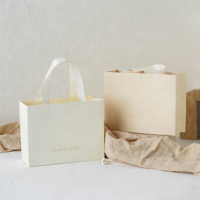 Sac shopping en papier d'art de luxe personnalisé avec logo en feuille d'or et poignée en ruban satiné, sac en papier de haute qualité pour l'emballage de vêtements, sac cadeau