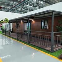 Maison conteneur extensible 20 pieds, structure noire, 2 chambres avec terrasse couverte et auvent pour complexe de glamping