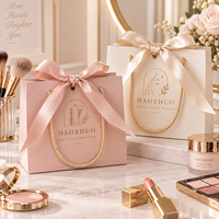 Sac cadeau de luxe personnalisé avec logo en feuille d'or gaufrée, en carton ivoire avec nœud en ruban de satin pour cliniques cosmétiques et salons de beauté