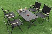 Table de camping en aluminium avec pieds renforcés et antidérapants, facile à installer, stable sur les surfaces en herbe et en gravier.