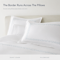 Parure de lit brodée à maillons ovales bleu poussière avec taie d'oreiller en satin blanc et bordure pour chambre à coucher