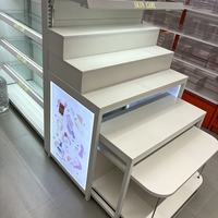Étagères de présentation pour supermarchés, système de rayonnage métallique LED pour magasins de maquillage et cosmétiques, étagères blanches à niveaux avec embouts.
