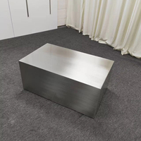 Table basse minimaliste en acier inoxydable pour petit espace de vie, avec finition mate brossée.