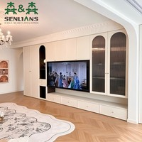 Meuble TV mural moderne de style français avec armoires en verre cintrées, niche de présentation noire, poignées dorées et moulures cannelées